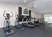 Thumbnail 8 of 19 - a gym with treadmills and weights and a tv on the wall