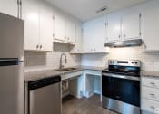 Thumbnail 14 of 19 - a kitchen with white cabinets and stainless steel appliances