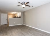 Thumbnail 15 of 19 - an empty living room with a ceiling fan and a kitchen