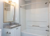Thumbnail 18 of 19 - a bathroom with a sink and a tub and a mirror