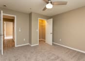 Thumbnail 16 of 19 - an empty living room with a ceiling fan and a door to a closet