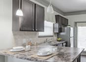 Thumbnail 49 of 49 - a kitchen with a marble counter top and a stainless steel refrigerator at Century HomePlace, Prattville, AL