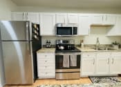 Thumbnail 16 of 31 - Kitchen with white shaker cabinets at Oasis at Twinwood in Wilmington, NC
