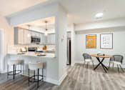 Thumbnail 5 of 31 - A kitchen with a bar stool and a table with chairs.