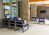 Thumbnail 30 of 36 - A patio with a couch, chairs, and a television.