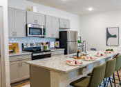 Thumbnail 1 of 36 - A kitchen with a table and chairs set for a meal.