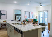Thumbnail 3 of 36 - A kitchen with a table and chairs and a counter with food on it.