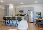 Thumbnail 2 of 36 - A modern kitchen with a dining table set for four.