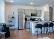 Thumbnail 10 of 36 - A modern kitchen with a large island and bar stools.
