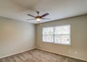 Thumbnail 10 of 29 - an empty bedroom with a ceiling fan and a window at Savan Pointe Townhomes East and West, Savannah, GA 31406