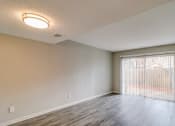 Thumbnail 19 of 29 - an empty living room with a large window and a sliding glass door at Savan Pointe Townhomes East and West, Savannah