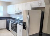 Thumbnail 21 of 29 - a kitchen with white cabinets and a refrigerator at Savan Pointe Townhomes East and West, Georgia