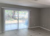 Thumbnail 22 of 29 - an empty living room with a sliding glass door to a patio at Savan Pointe Townhomes East and West, Savannah Georgia