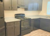 Thumbnail 27 of 29 - a kitchen with stainless steel appliances and white counter tops at Savan Pointe Townhomes East and West, Savannah, GA