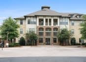 Thumbnail 20 of 22 - an apartment building with a driveway and trees in front of it