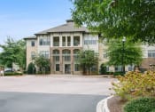 Thumbnail 9 of 22 - a large building with a driveway and trees in front of it