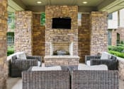 Thumbnail 6 of 22 - a patio with wicker furniture and a stone fireplace