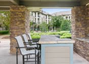 Thumbnail 4 of 22 - a bar with chairs and a table on a patio