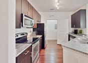 Thumbnail 11 of 22 - a modern kitchen with granite counter tops and stainless steel appliances