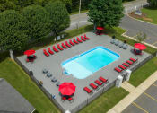 Thumbnail 26 of 53 - a swimming pool with red umbrellas and chairs around it at The Dylan, Murfreesboro Tennessee