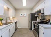 Thumbnail 3 of 53 - a kitchen with stainless steel appliances and white cabinets at The Dylan, Tennessee 