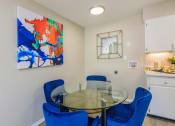 Thumbnail 9 of 53 - a dining room with a glass table and blue chairs at The Dylan, Murfreesboro, TN
