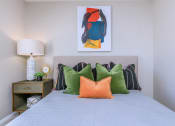 Thumbnail 10 of 53 - a bedroom with a bed with colorful pillows and a painting on the wall at The Dylan, Murfreesboro, 37129