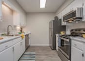 Thumbnail 8 of 53 - a kitchen with stainless steel appliances and white cabinets at The Dylan, Tennessee