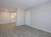 Thumbnail 48 of 53 - an empty living room and kitchen with wood flooring and a white door at The Dylan, Murfreesboro Tennessee