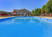 Thumbnail 22 of 53 - a large pool with chairs and umbrellas next to a house at The Dylan, Murfreesboro, TN 