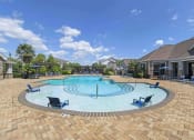 Thumbnail 8 of 49 - a large swimming pool with chairs around it in front of a house at Century HomePlace, Prattville Alabama