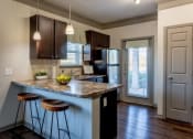 Thumbnail 31 of 49 - a kitchen with an island with stools and a refrigerator at Century HomePlace, Prattville
