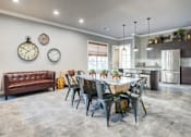 Thumbnail 19 of 38 - A modern dining room with a brown leather couch, a dining table set with plates, and three wall clocksat Century Ariva, Lakeland Florida  .