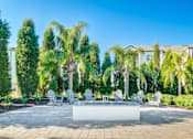 Thumbnail 7 of 38 - A patio with a white table surrounded by trees and chairs.at Century Ariva, Florida  