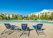 Thumbnail 8 of 38 - A pool surrounded by chairs and trees with a building in the background.at Century Ariva, Florida, 33812