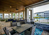 Thumbnail 27 of 38 - A patio with a table and chairs overlooking a pool.at Century Ariva, Lakeland  