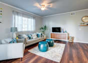 Thumbnail 32 of 38 - A living room with a white couch, a blue ottoman, and a wooden floor.at Century Ariva, Lakeland, 33812  