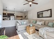 Thumbnail 3 of 48 - A living room with a couch, a coffee table, and a ceiling fan.at Century Hampton Roads, Suffolk  