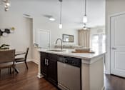 Thumbnail 9 of 48 - A modern kitchen with a black dishwasher and a wooden floor.at Century Hampton Roads, Virginia, 23435