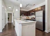 Thumbnail 11 of 48 - A modern kitchen with a white island and stainless steel appliances.at Century Hampton Roads, Suffolk  