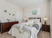 Thumbnail 16 of 48 - A bedroom with a large bed, two nightstands, and a wall art of a plant.at Century Hampton Roads, Suffolk Virginia  