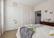 Thumbnail 19 of 48 - A bedroom with a bed, dresser, and two doors.at Century Hampton Roads, Virginia  