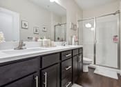 Thumbnail 25 of 48 - A bathroom with a white sink and black cabinets.at Century Hampton Roads, Suffolk, VA 23435  