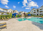 Thumbnail 1 of 48 - A swimming pool surrounded by lounge chairs and umbrellas in a residential area.at Century Hampton Roads, Virginia  