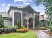 Thumbnail 1 of 24 - A house with a grey roof and a stone archway entrance at Ridge Crossings Apartments, Hoover, AL 35244