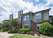 Thumbnail 24 of 24 - A grey house with a red brick base and a grey roof at Ridge Crossings Apartments, Alabama
