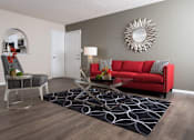 Thumbnail 19 of 24 - A living room with a red couch, a chair, and a coffee table at Ridge Crossings Apartments, Hoover, AL