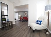 Thumbnail 18 of 24 - A living room with a white chair and a blue pillow that says smile at Ridge Crossings Apartments, Hoover, AL 35244