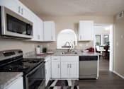 Thumbnail 21 of 24 - A kitchen with white cabinets and a black and white checkered floor at Ridge Crossings Apartments, Hoover, Alabama