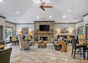 Thumbnail 3 of 24 - A living room with a stone fireplace and a flat screen TV at Ridge Crossings Apartments, Hoover